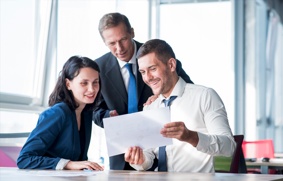 des employé d'une entreprise regardent une feuilles et se font prendre en photo par un photographe corporate dans le Grand Est