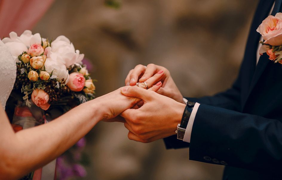 marié mettant la bague à sa femme et se fait prendre en photo par une équipe de photographes en Auvergne-Rhone-Alpes