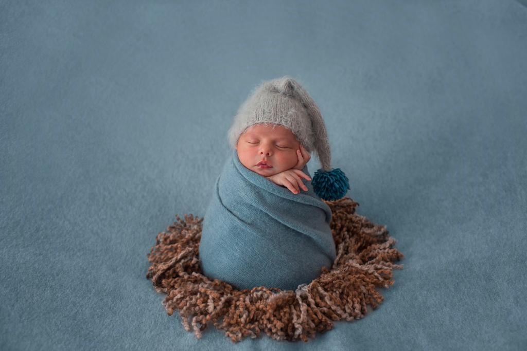 nouveau-né se fait prendre en photo dans un studio photo à La Réunion      est enroulé dans une couverture 